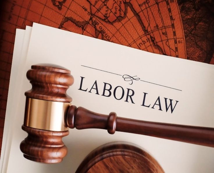 a wooden judge's gavel next to a labor law paper