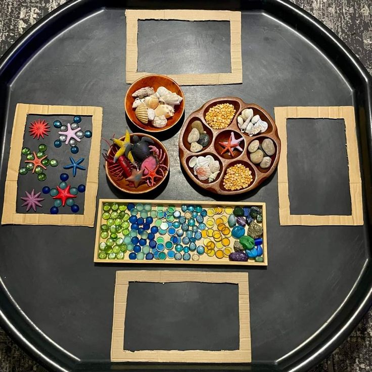 a tray with several different types of beads on it and two bowls filled with them