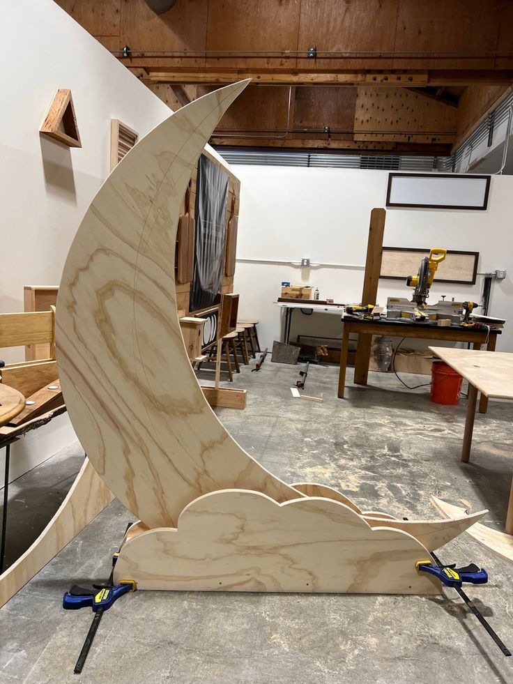 a wooden sculpture sitting on top of a table in a room filled with woodworking tools