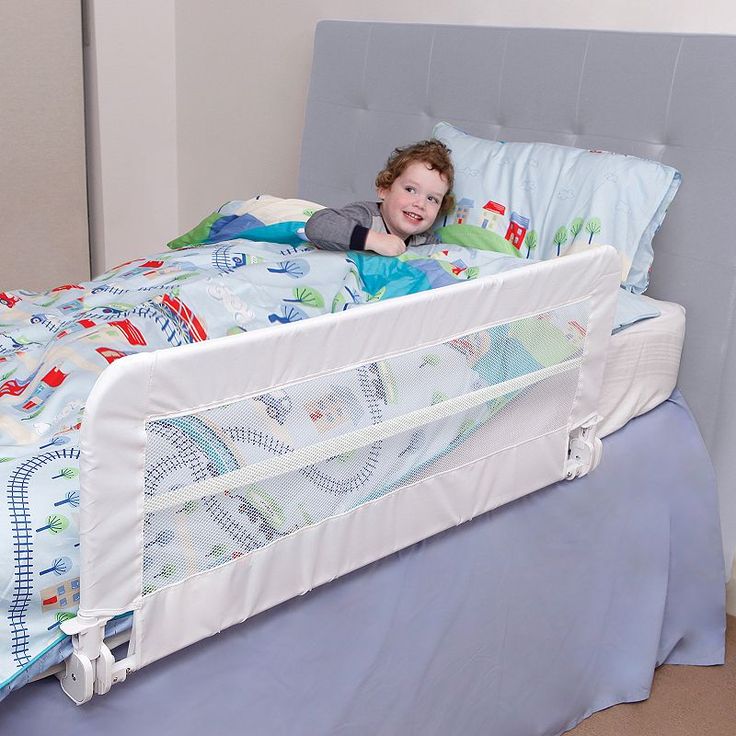 a little boy laying in his bed with a pillow