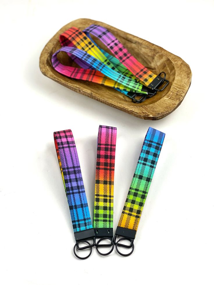 three pairs of multicolored checkered lanyards on a wooden tray