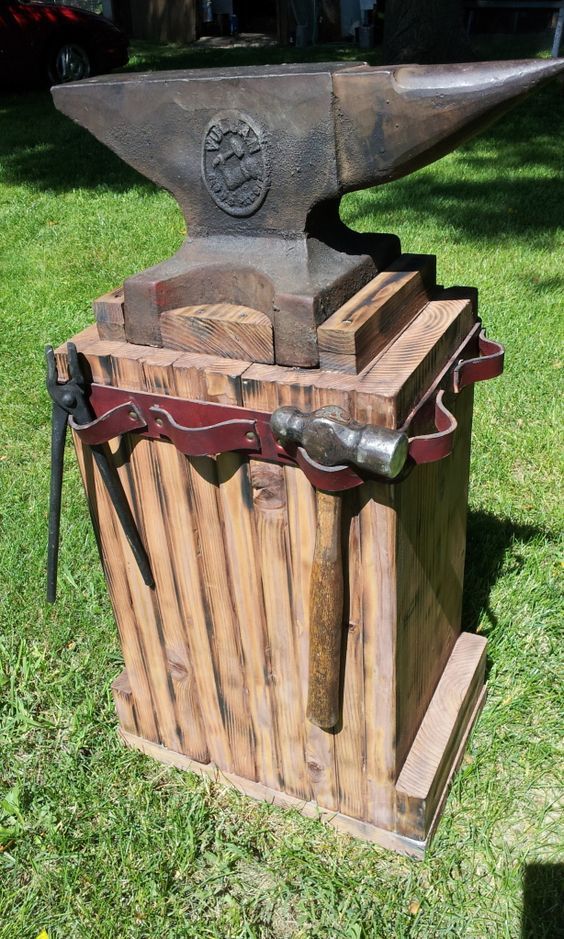 an old wooden tool box sitting on top of green grass next to a large hammer