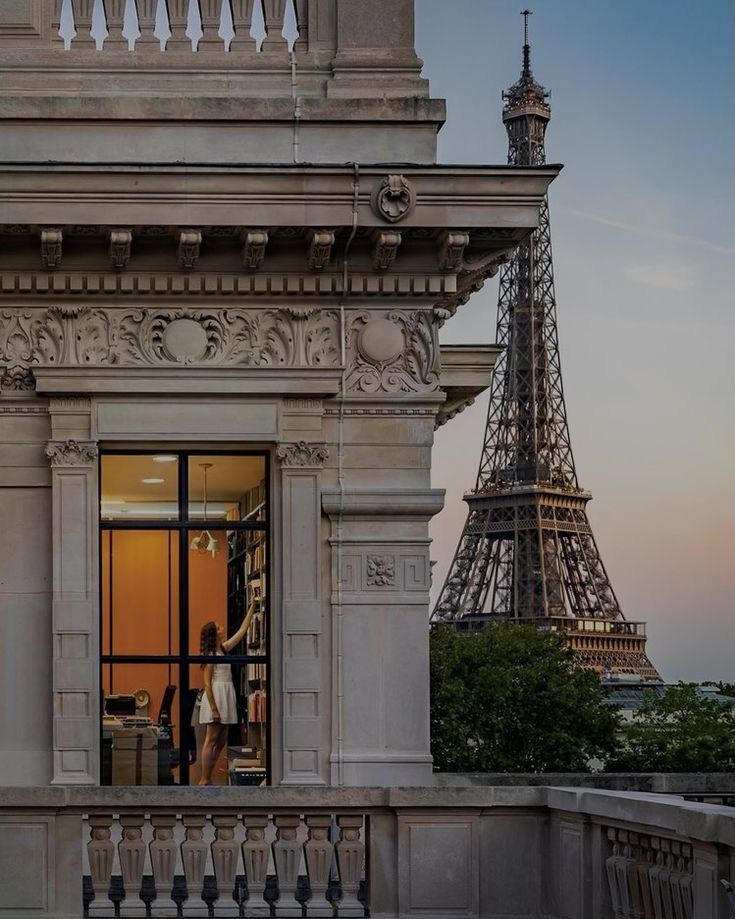 the eiffel tower is in the background and people are standing at the entrance