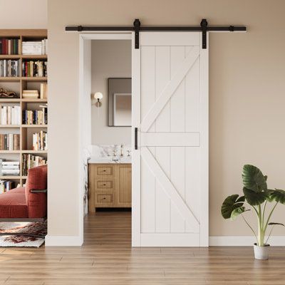 an open door leading to a living room with bookshelves