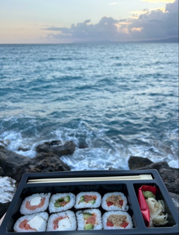 some sushi is sitting on the rocks by the water