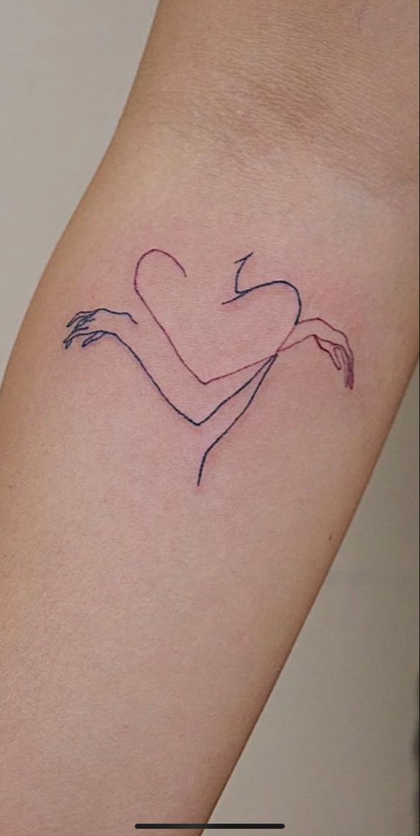 a woman's arm with a heart tattoo on the left side of her arm