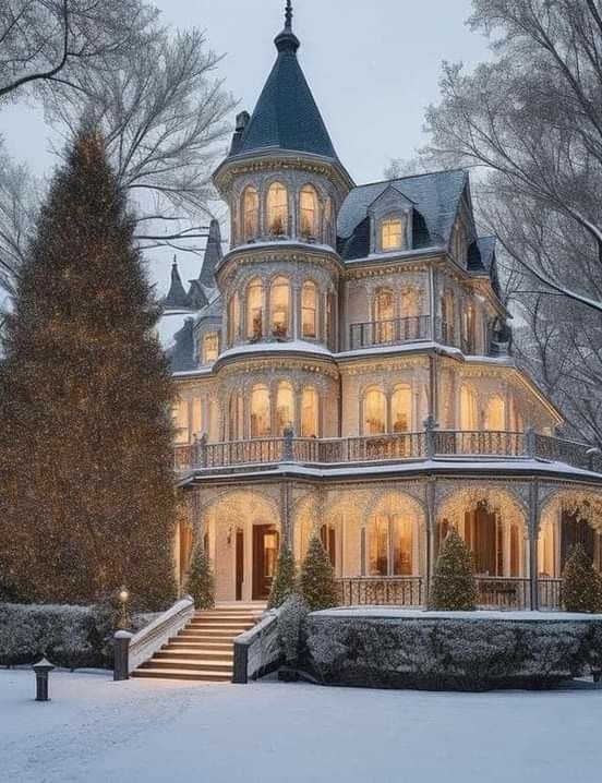 a large victorian style house is lit up in the snow at night with christmas lights on