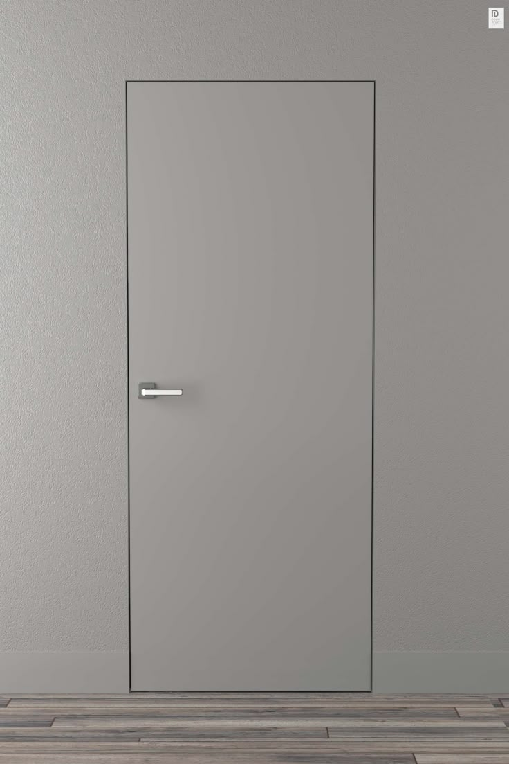 an empty room with a white door and wood flooring on one side, and a gray wall on the other