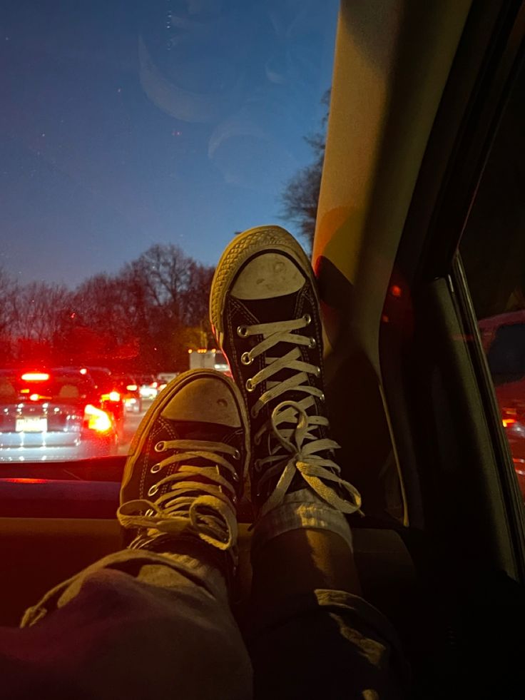 someone's feet in the passenger seat of a car at night