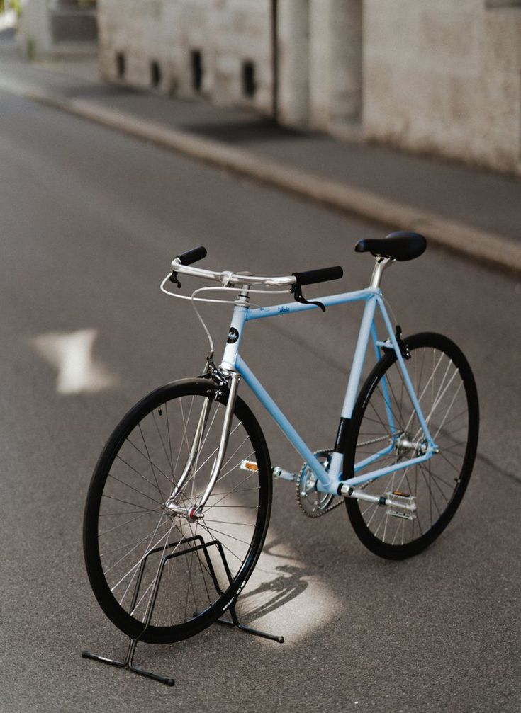 a blue bicycle is parked on the side of the road