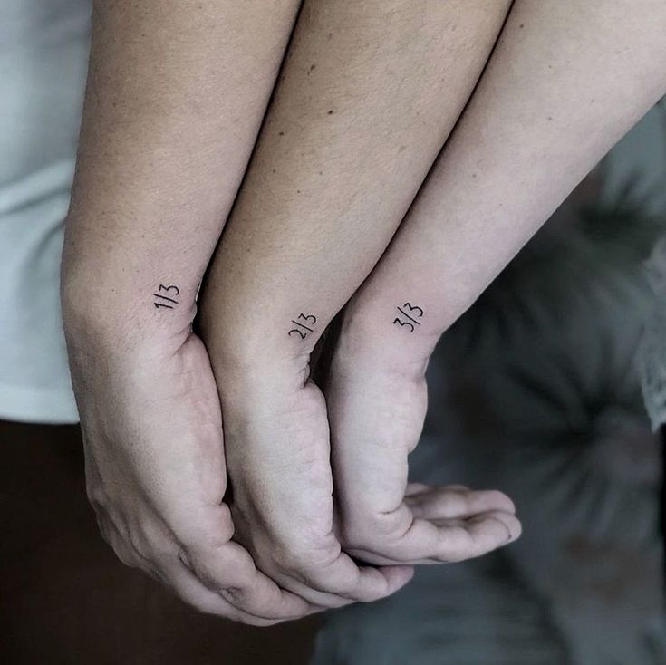 two people are holding hands with small tattoos on their arms and one has the word love written