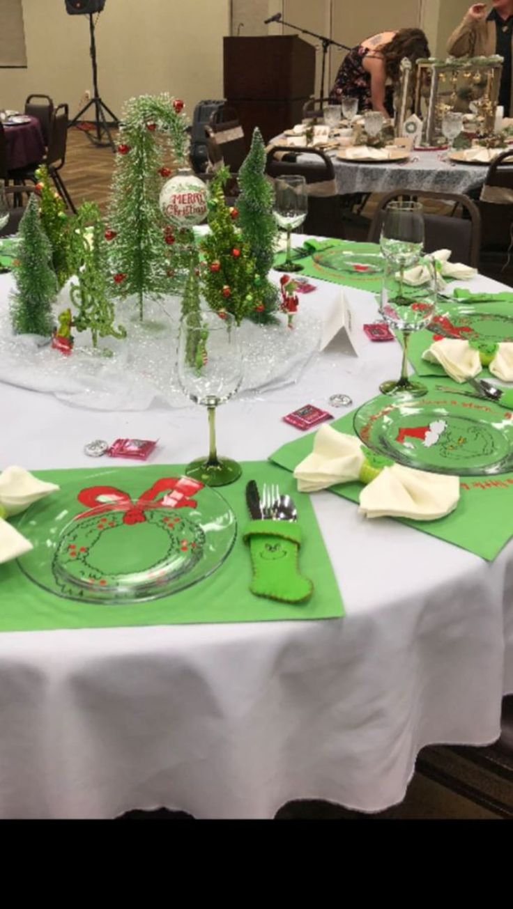 the table is set with green plates and silverware