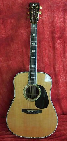 an acoustic guitar sitting on top of a red cloth