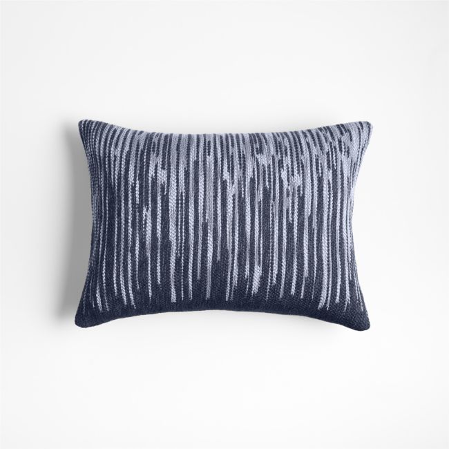 a blue and white pillow on a white wall