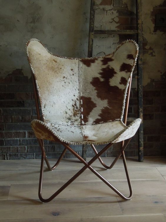 a chair that has some kind of animal print on it, sitting in front of a brick wall