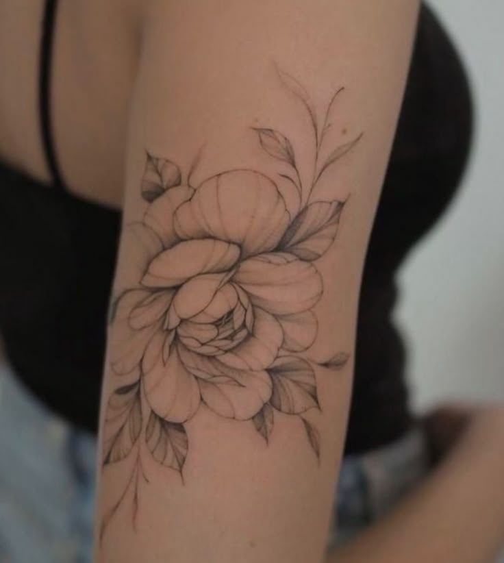 a woman's arm with a flower tattoo on it