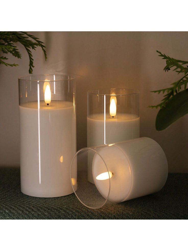 three lit candles sitting next to each other on a table