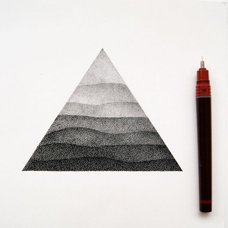 a pen is next to a drawing of a triangular shape with mountains in the background