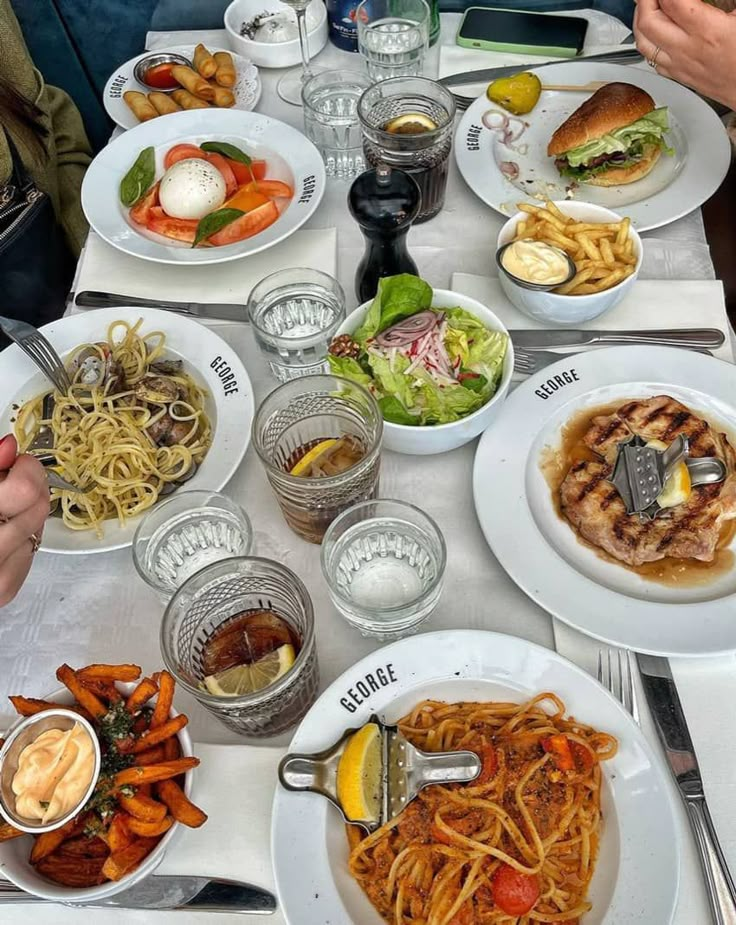 a table topped with lots of plates of food