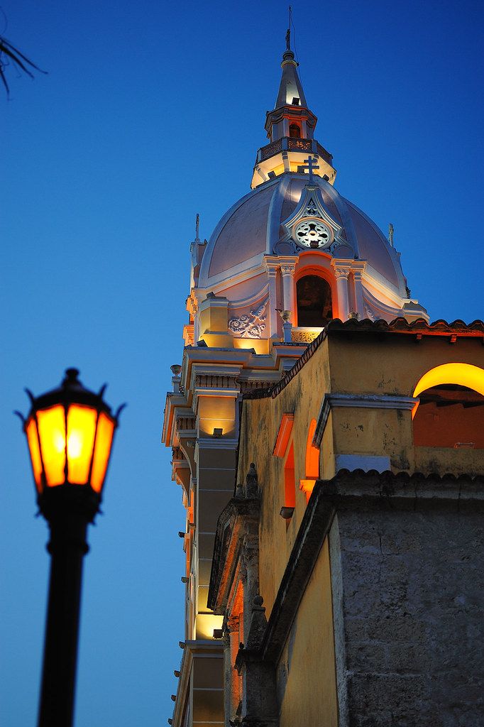 a tall building with a clock on it's side and a street light next to it