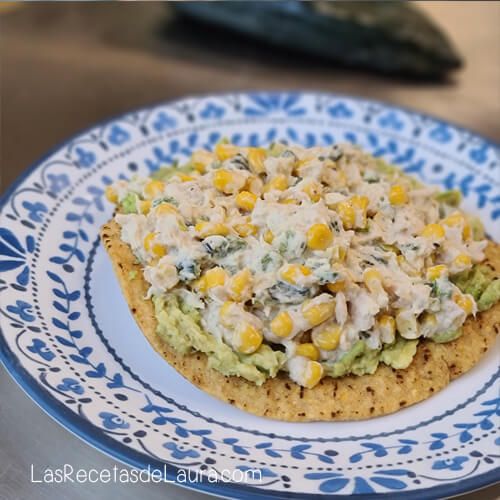 a plate with corn and chicken salad on it