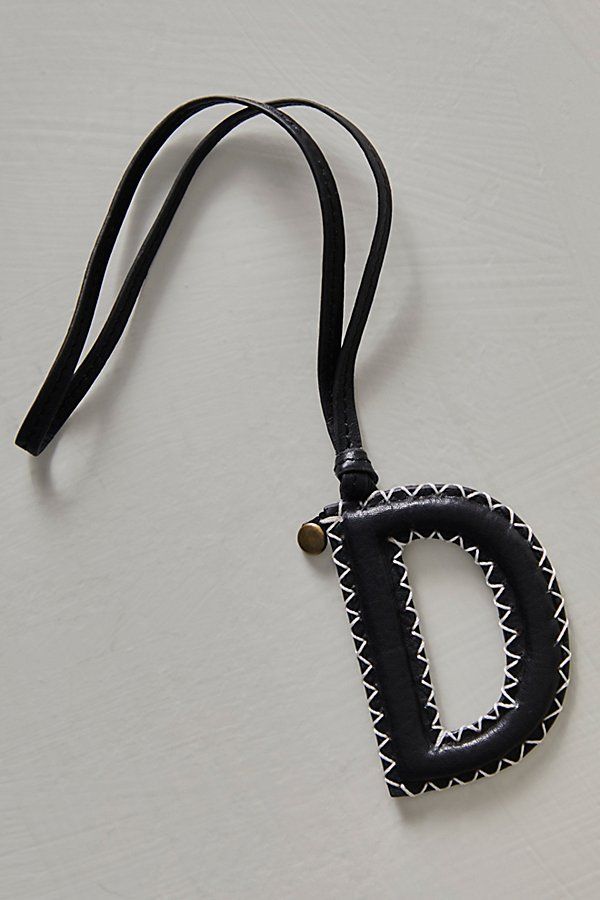 a black and white necklace with the letter d hanging from it's end on a cord