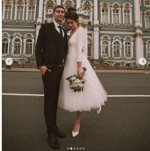 a bride and groom standing in front of an ornate building