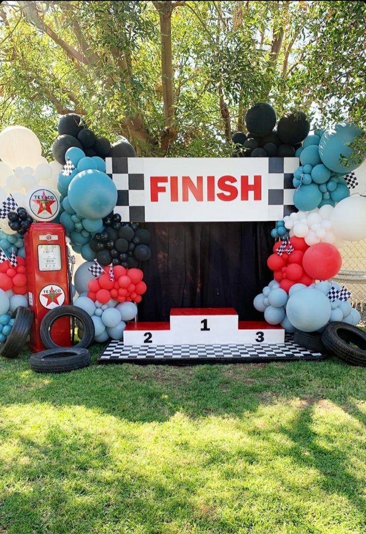 a car themed birthday party with balloons and streamers in the shape of race cars