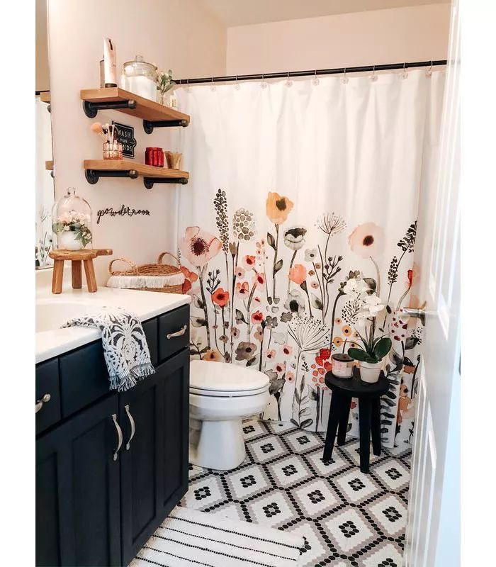 a bathroom with black and white tile flooring next to a sink, toilet and shower