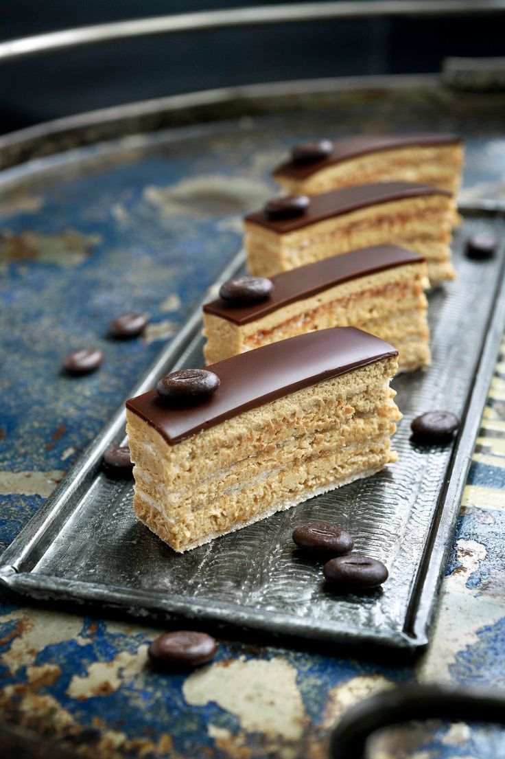 three pieces of cake sitting on top of a metal tray with chocolate chips around it