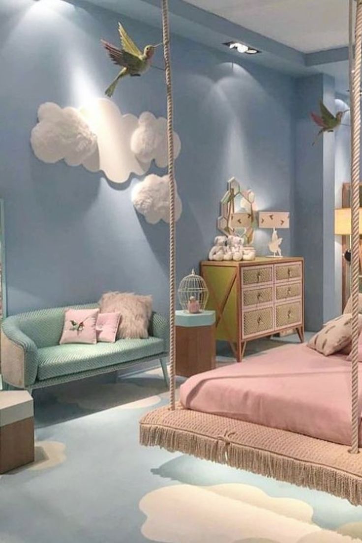 a bedroom decorated in blue and pink with birds on the ceiling, hanging bed frame