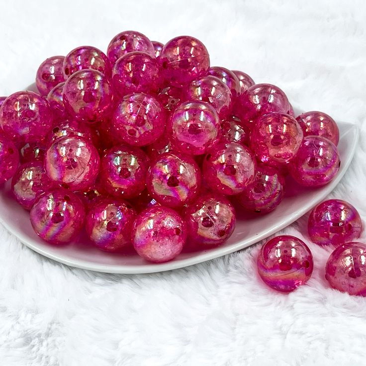 a plate filled with pink glass balls on top of a white furnishing floor