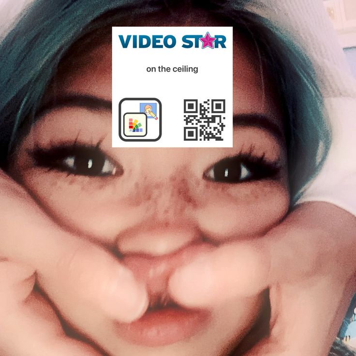 a woman holding her face with a video star sticker on it's forehead