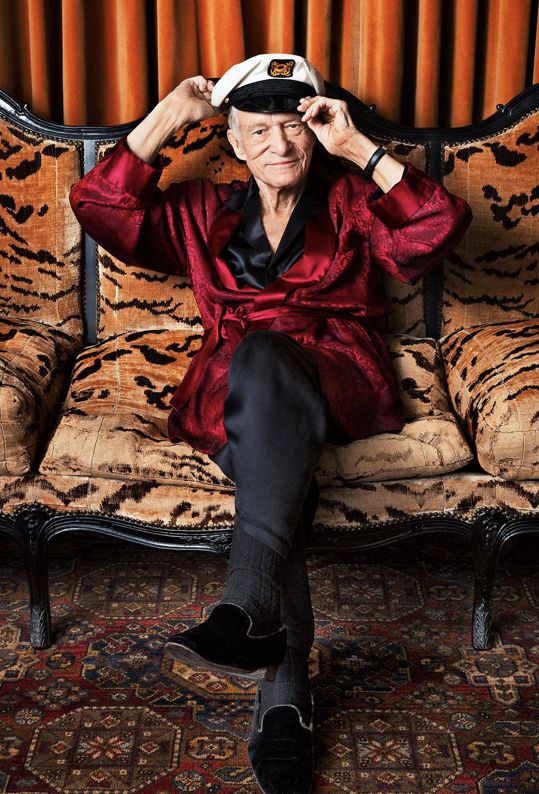 an older woman sitting on top of a couch with her hands to her head and wearing a sailor's hat