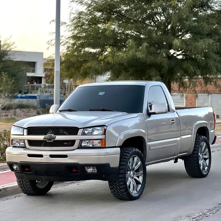 a silver truck is parked on the street