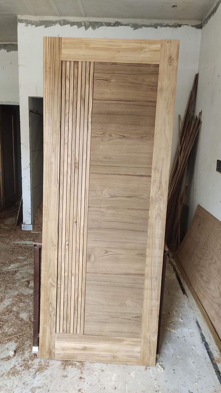 an unfinished wooden door in the middle of a room