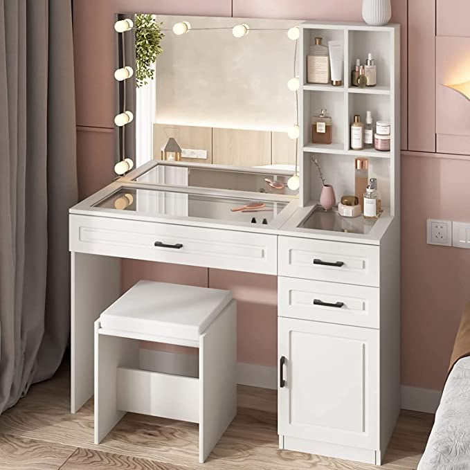 a white vanity with lights on it next to a bed in a pink walled room