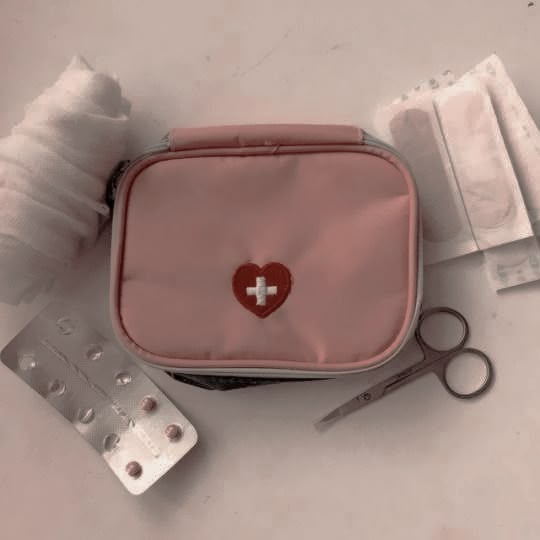 a first aid kit is sitting on the table next to some bandages and other medical supplies