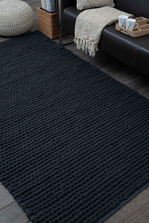 a living room with a black couch and rug