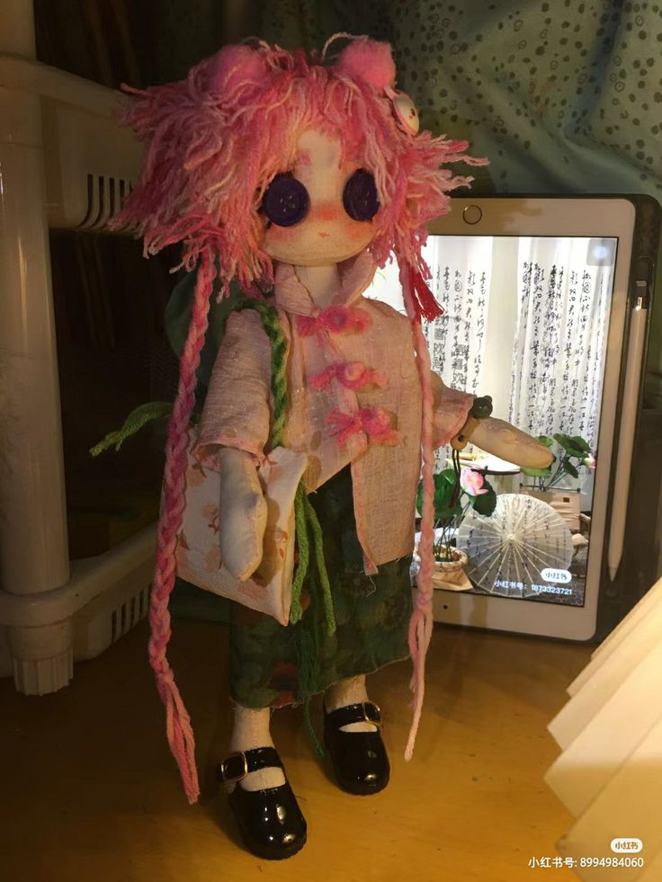 a doll with pink hair standing in front of a mirror