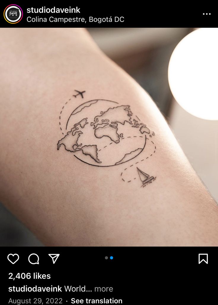 a person with a small tattoo on their arm that has a world map and airplanes flying around it