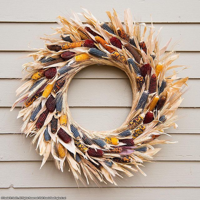 a wreath made out of dried corn on the side of a house