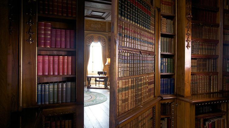 an open bookcase with many books on it in a room filled with wooden shelves