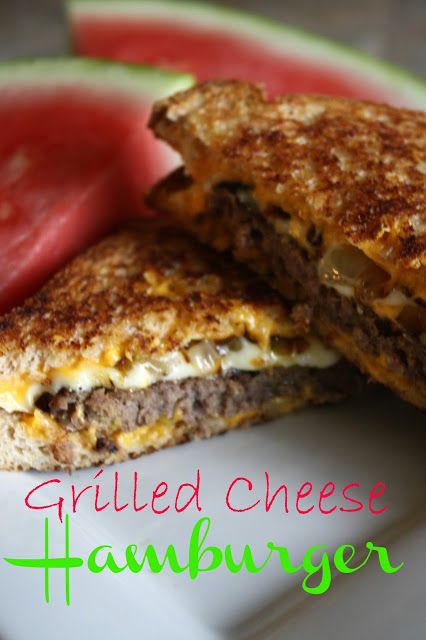 a grilled cheeseburger is cut in half on a white plate with a red pepper