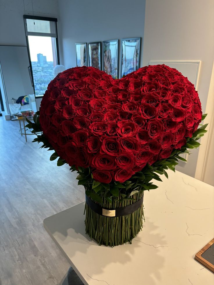 a heart shaped arrangement of red roses in a vase