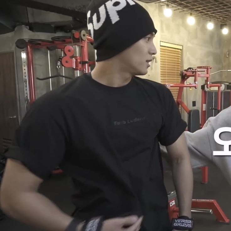 two young men standing next to each other in a gym