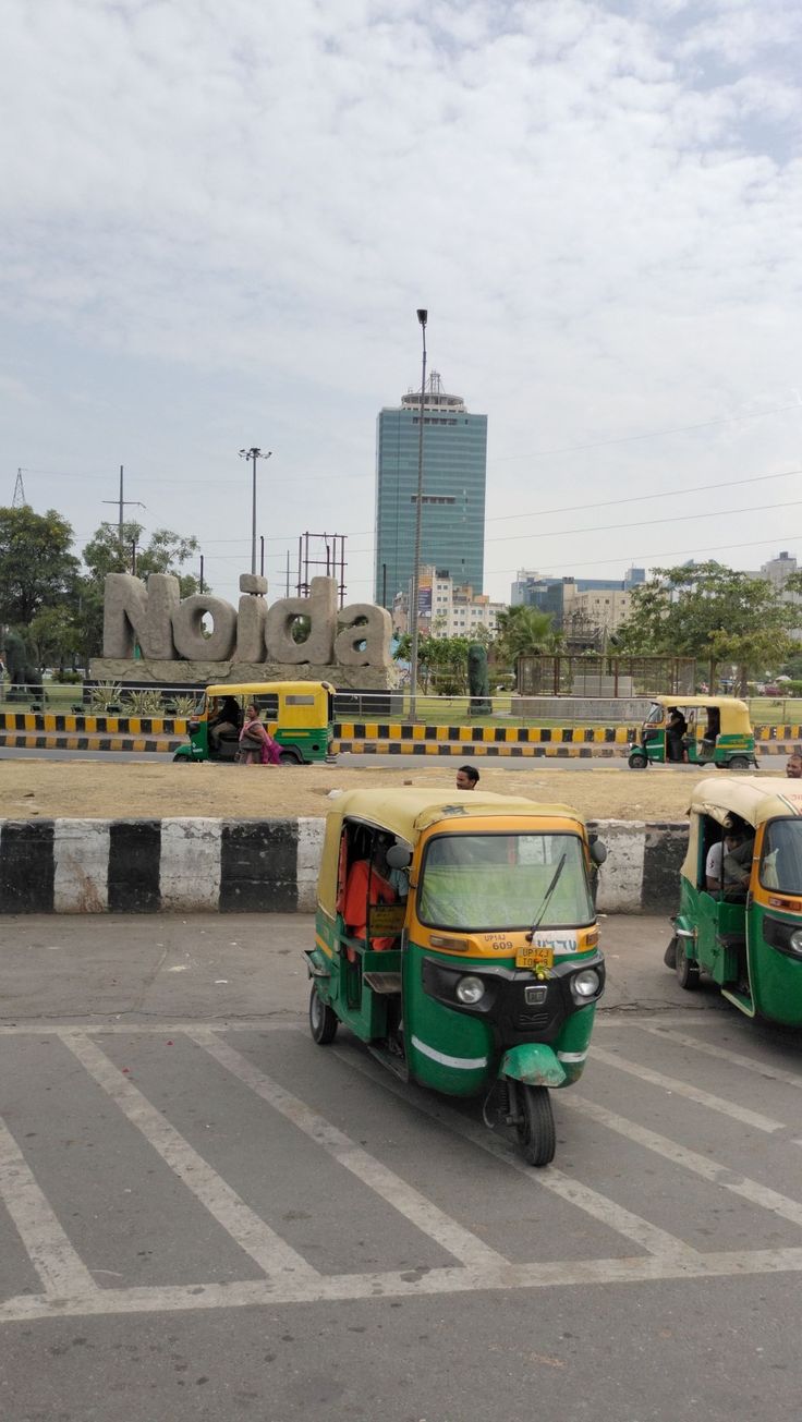 two green and yellow tuks parked in front of a large sign that says go