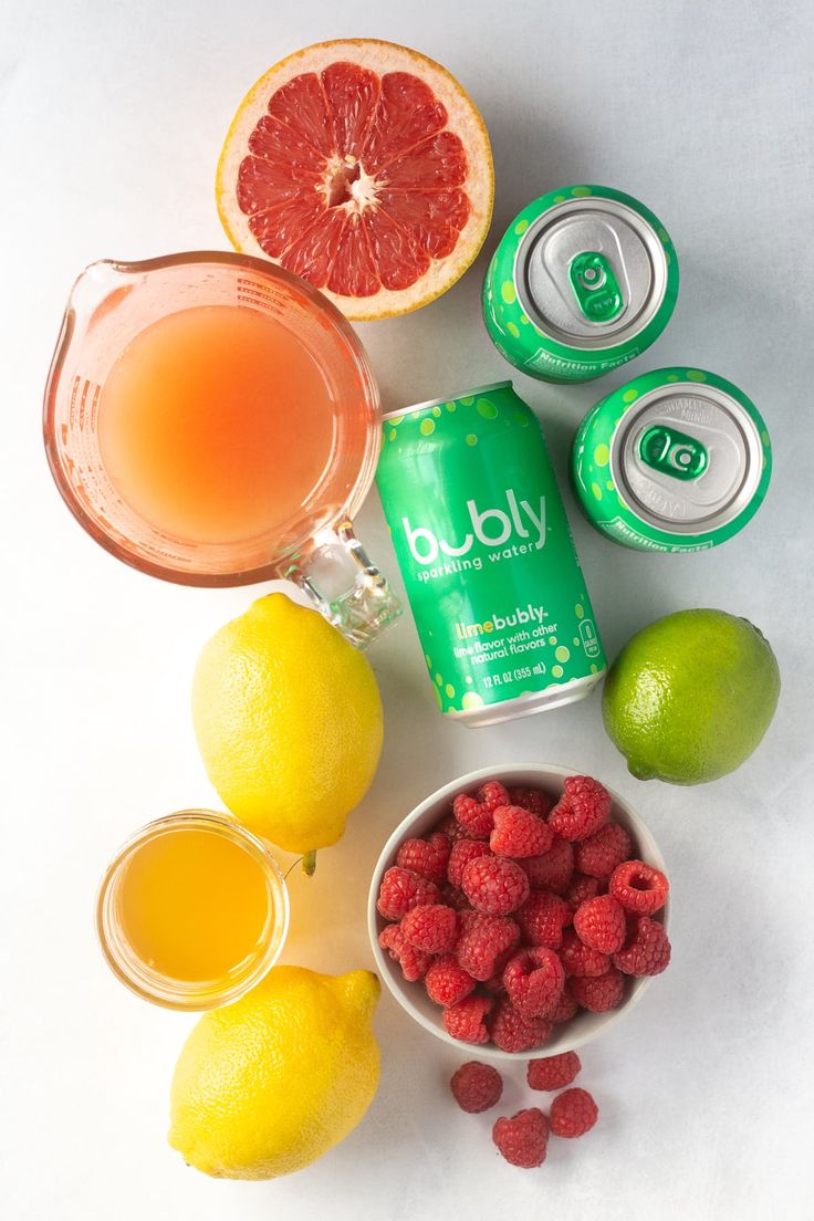 various fruits and drinks are arranged on a white surface