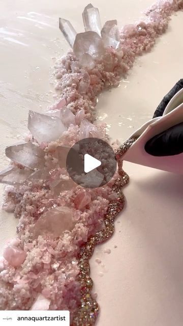 a woman is using scissors to cut pink crystals