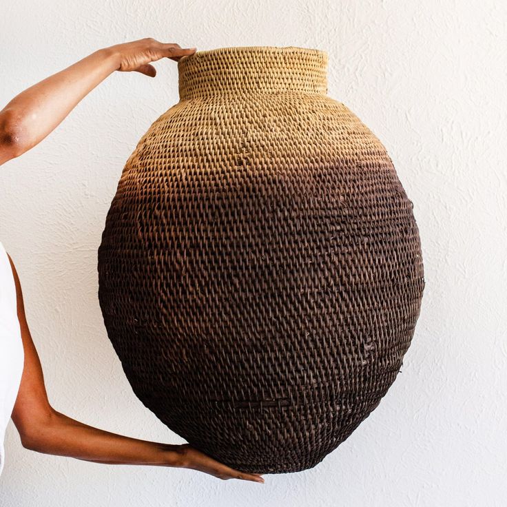 a woman holding a large woven basket over her head